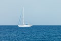 A lone white yacht with lowered sails stands in the waters of the Mediterranean Sea Royalty Free Stock Photo