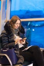 A lone woman in the evening at the airport by the window waiting for a landing on the plane