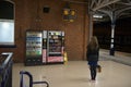 Lone woman studies doncaster train station departure board at night