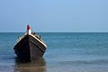 A lone wooden boat floating in the waters of the blue sea