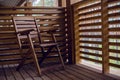 Lone wooden chair on the balcony of wood with baffles