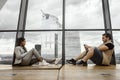 A couple sitting together by huge glass window, but thinking about different things, London, UK Royalty Free Stock Photo