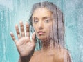 Loneliness can be unkind. a young woman washing in a shower against a blue background. Royalty Free Stock Photo