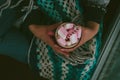 Loneliness christmas - girl sitting alone holding cup with marshmallow in a hands. Royalty Free Stock Photo