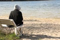 Loneliness concept. Sad man sitting on bench at beach Royalty Free Stock Photo