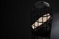 Loneliness epidemic, solitary confinement as torturer and isolation kills concept with wood coffin locked in a black cage