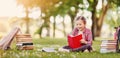 Loneliness girl sitting on the green meadow and readung a book. Royalty Free Stock Photo