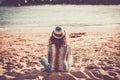 Loneliness and meditation outdoor leisure atiity with back view of trendy woman sit dowon on the sand at the beach looking and Royalty Free Stock Photo