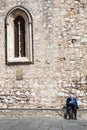 Loneliness retired elderly man reading newspaper. Ancient wall and window