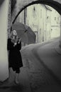 Lonelly woman with umbrella in a street, retro