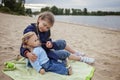 Lonely adorable eight years girl playing with doll on the autumn beach, mother and daughter game