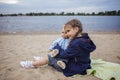 Lonely adorable eight years girl playing with doll on the autumn beach, mother and daughter game