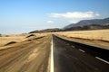 Lonely asphalt road through barren waste land into endlessness of Atacama desert, Chile Royalty Free Stock Photo