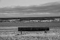 A lonely beach bench at the waters of the turbulent sea rich in winds