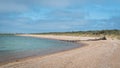 Lonely beach with driftwood log by the serene waters Royalty Free Stock Photo