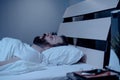 A lonely bearded man sleeps at night with his mouth open, snoring. Apnea syndrome, bedroom, pajamas, white bedding Royalty Free Stock Photo