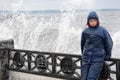 Lonely beatyfull girl in icy splashes of storm waves on the riverside with metal embankment Royalty Free Stock Photo