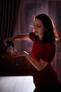 Lonely beautiful middle aged woman alone in the dark kitchen drinking red wine in the evening Royalty Free Stock Photo