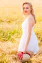 Lonely beautiful young blonde girl in white dress with straw hat Royalty Free Stock Photo