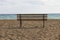 A lonely bench on an empty beach near the blue sea Royalty Free Stock Photo