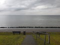 A lonely bench before the view of a cold Northern sea under the pale autumn skies Royalty Free Stock Photo