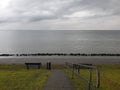 A lonely bench before the view of a cold Northern sea under the pale autumn skies