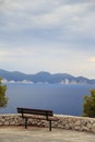 A lonely bench on the hill of Assos peninsula with a fantastic view on Cephalonia island azure sea water and cliffs