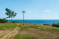 A lonely bench and a lantern on the edge of a mountain by the sea. Park by the sea, the sun Royalty Free Stock Photo