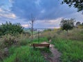 A lonely bench in the middle of the forest on the mountain, and a cloudy view Royalty Free Stock Photo