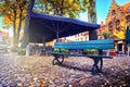 Lonely bench and outdoor cafe in autumn city Royalty Free Stock Photo