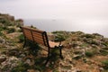 A lonely bench on a rocky ocean coast Royalty Free Stock Photo