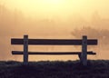 Lonely bench at shore of lake in foggy morning Royalty Free Stock Photo