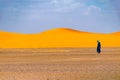 Lonely berber man walking in desert, Merzouga, Sahara Desert, Morocco Royalty Free Stock Photo