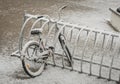A lonely bicycle covered with fresh snow due to weather phenomena