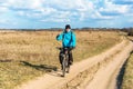 Lonely bike traveler, young man in a blue jacket on a Bicycle