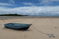 A lonely blue boat on the sand at the Carapitangui river in Barra Grande, with view to the exhuberant Camamu Bay in Bahia Brazil