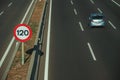 Lonely blue car on highway and SPEED LIMIT signpost in Madrid Royalty Free Stock Photo