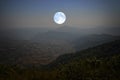 Lonely blue moon over the valley in the night Royalty Free Stock Photo