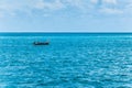Lonely boat in the ocean with blue sky on the background Royalty Free Stock Photo