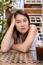 Lonely bored Asian woman waiting for her friend alone in the coffee shop. Royalty Free Stock Photo