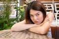 Lonely bored Asian woman waiting for her friend alone in the coffee shop. Royalty Free Stock Photo