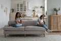 Lonely bored teenage girl sitting on sofa with working online mother, need attention from parent Royalty Free Stock Photo