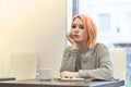 Lonely bored young girl sitting at a table in a cafe, leaning he Royalty Free Stock Photo