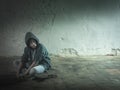 Lonely boy sitting on his skateboard. Royalty Free Stock Photo