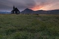Lonely Budakirkja christian church sits among a field of lava rock