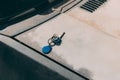 Lonely bunch of blue magnet keys on dirty old and rusting car, on the street.