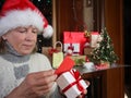 Lonely Caucasian senior woman in Santa hat on video call on laptop, with christmas tree and gifts Royalty Free Stock Photo