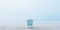 Lonely chair on white sand of tranquil beach of sea covered with mist. Generative AI