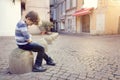 Lonely child sitting on a street corner