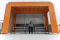 lonely child waiting for a bus at an empty bus stop in winter